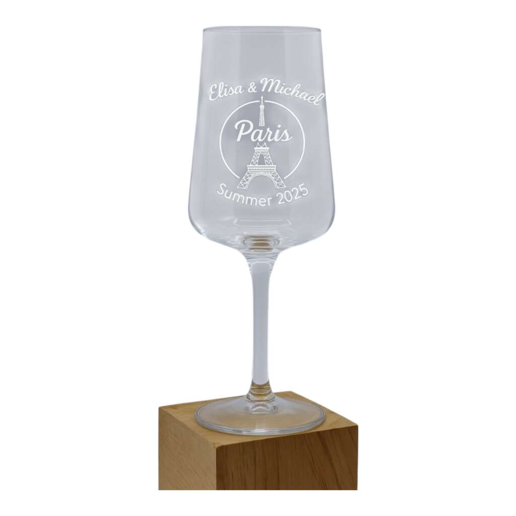 Elegant wine glass engraved with 'Elisa & Michael Paris Summer 2025' and an Eiffel Tower motif, mounted on a wooden block.