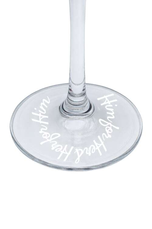 Close-up of the base of a clear wine glass with engraved white script text.
